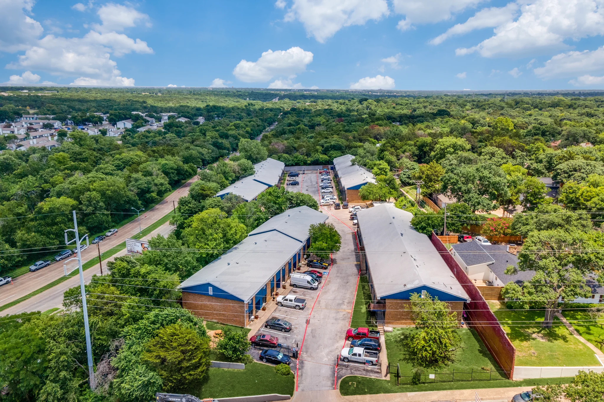 The property from the air, four buildings around a central drive inside a tree canopy.