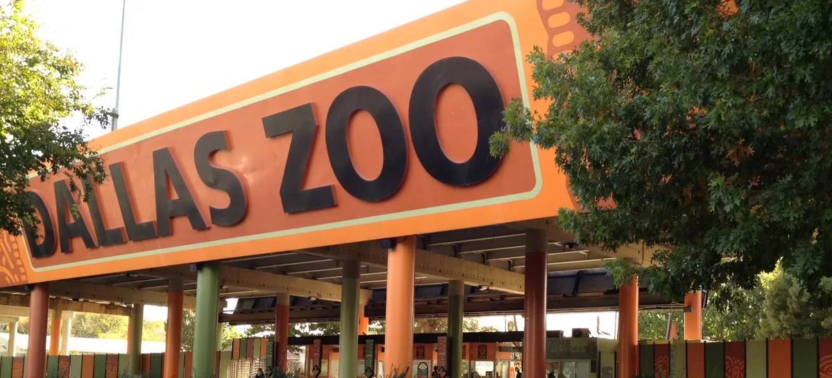 The Dallas Zoo entrance sign above the covered walkway at the main gate.