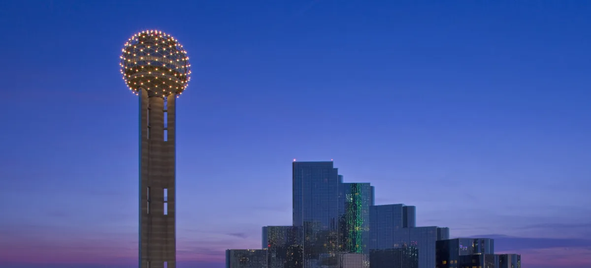 The downtown Dallas skyline at dusk, with the lit sphere of Reunion Tower in front.
