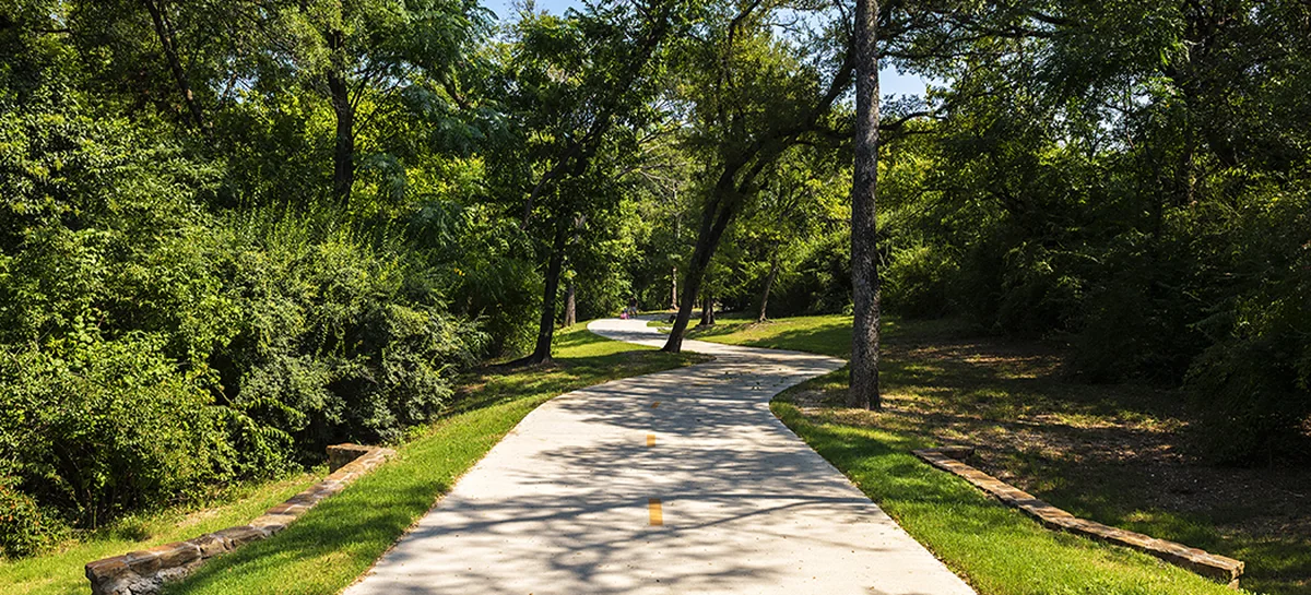 The paved Kiestwood Trail curving away between mature trees.