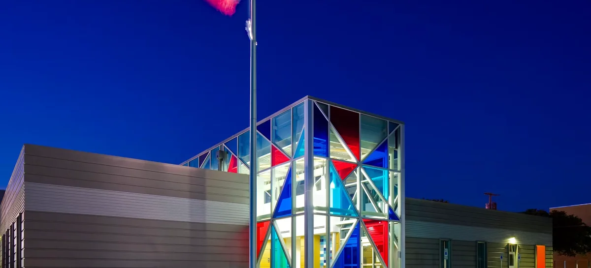The stained glass frontage of the Polk-Wisdom Branch Library lit at dusk.